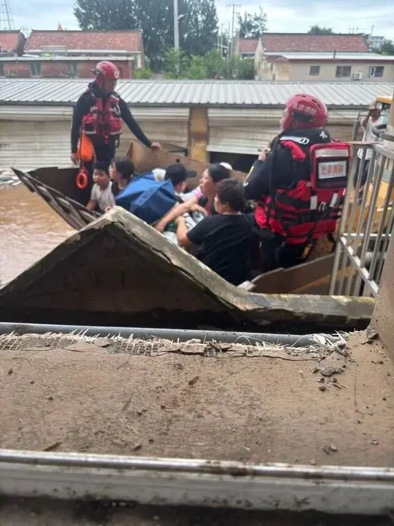 消防人员护送居民搭铲车转移